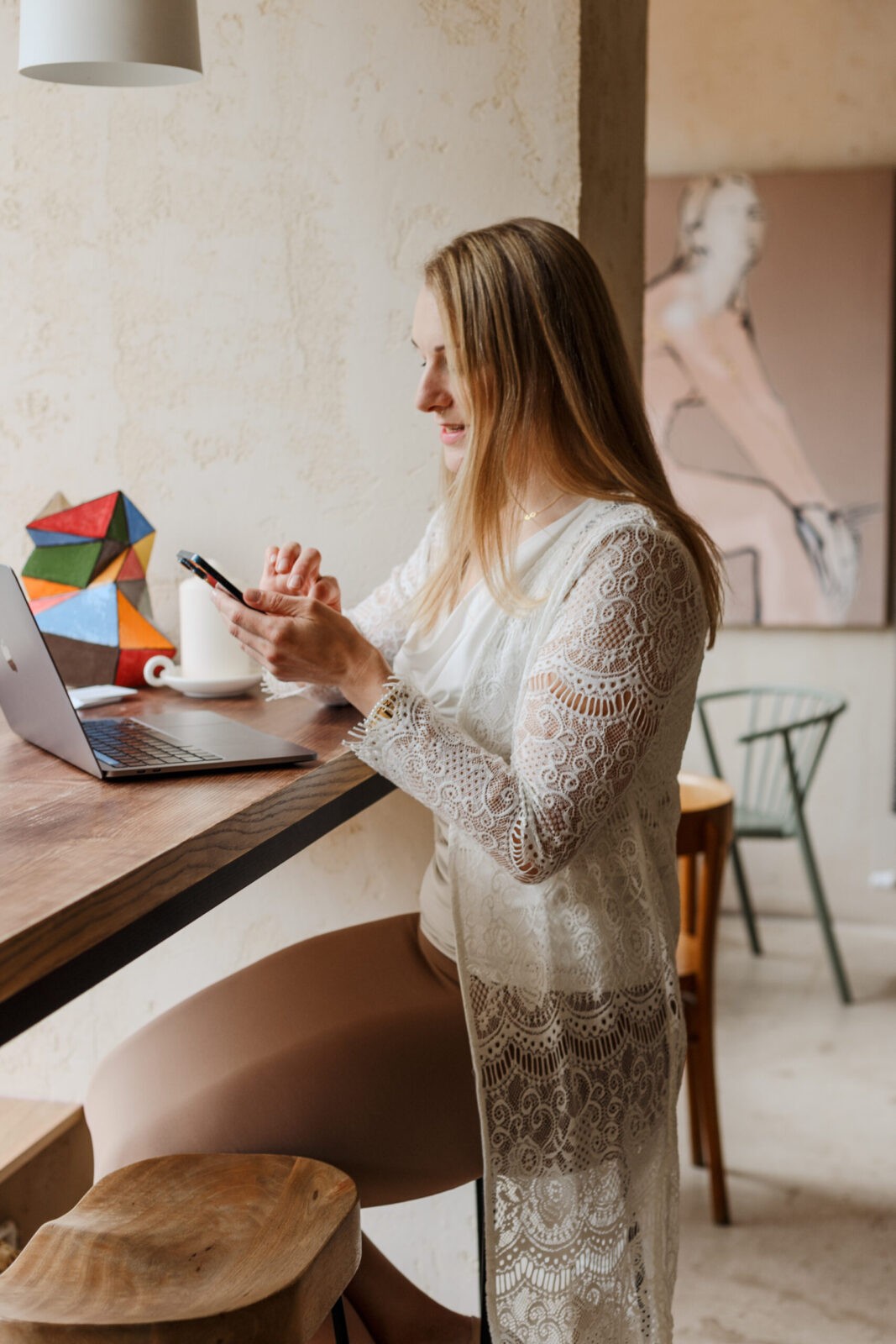 Kobieta przy biurku z telefonem, kontakt w sprawie nauki języka i przełamania bariery językowej.