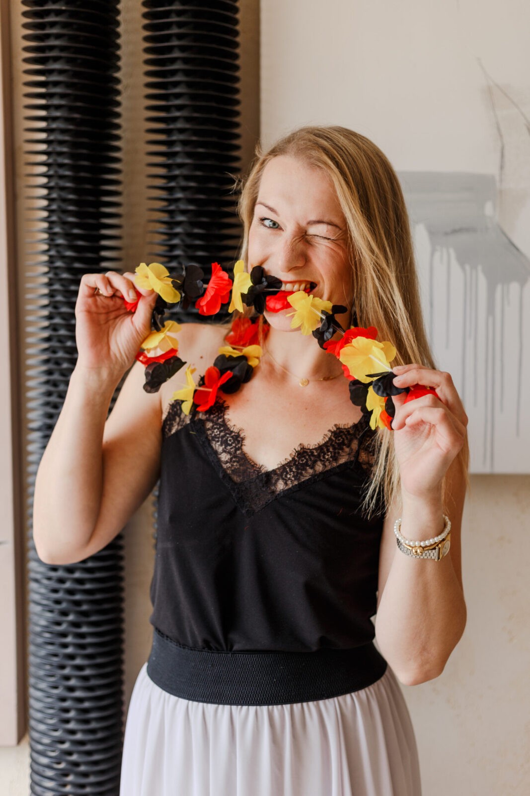 kobieta stojąca z flagą niemiecką, pokazująca, że nie boi się tego języka i potrafi mówić